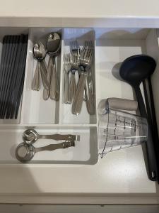a drawer filled with silver utensils on a counter at CROWN 越中島 in Tokyo