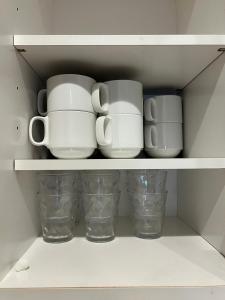 a white cupboard with cups and mugs in it at CROWN 越中島 in Tokyo