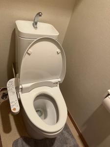 a bathroom with a white toilet with a remote control at CROWN 越中島 in Tokyo