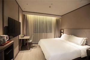 Hanting Hotel Zhengzhou Shakou Road tesisinde bir odada yatak veya yataklar