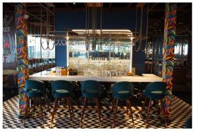 a bar with blue bar stools in a room at Mastiff Hotel Dhanbad in Dhanbād +7 photos