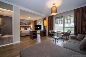 ein Hotelzimmer mit einem Bett und einem Wohnzimmer in der Unterkunft Fletcher Hotel-Restaurant Arneville-Middelburg in Middelburg