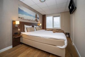 een slaapkamer met een groot bed en een raam bij Fletcher Hotel-Restaurant Arneville-Middelburg in Middelburg