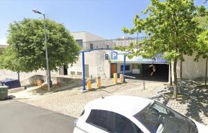 um carro branco estacionado em frente a um edifício em Afonso Galo Guest Apartments IV em Almada