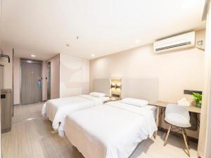 Łóżko lub łóżka w pokoju w obiekcie Hanting Hotel Shenzhen Tai'an Metro Station