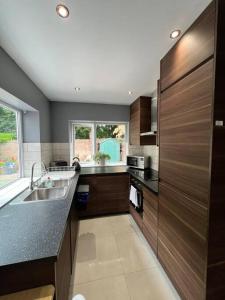 a kitchen with wooden cabinets and a sink and a window at Promotion, Half Price 1 Bed Flat By Richmond Park in London