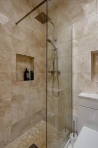 a shower with a glass door in a bathroom at Promotion, Half Price 1 Bed Flat By Richmond Park in London