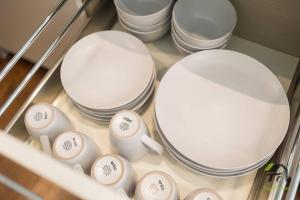 a bunch of white plates and cups in a drawer at 'Lynwood' Warrawee Manor- Koi Home in Warrawee