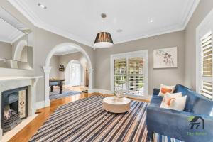 a living room with a blue couch and a fireplace at 'Lynwood' Warrawee Manor- Koi Home in Warrawee