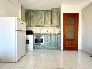 eine Küche mit grünen Schränken und einem weißen Gerät in der Unterkunft Costa Daurada Apartaments - LA SIRENA in Salou