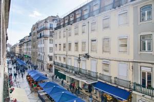 eine Straße in einer Stadt mit Gebäuden und Passanten in der Unterkunft Rua Augusta Dream Apartment in Lissabon