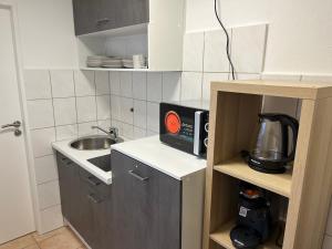 a small kitchen with a microwave and a sink at Nauheim-Residenz in Bad Nauheim