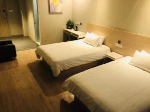 Un pat sau paturi într-o cameră la Hi Inn Nanjing Xingang Development Zone