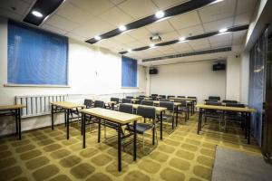 une salle de classe avec des tables et des chaises dans une salle dans l'établissement Hanting Hotel Shenyang Wanlian Metro Station, à Shenyang