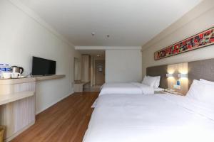 Hanting Hotel Guiyang Huaguoyuan Twin Towers tesisinde bir odada yatak veya yataklar