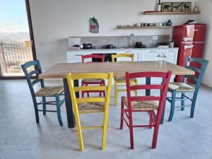 cocina con mesa de madera y sillas coloridas en Agriturismo San Nicolino, en Offida