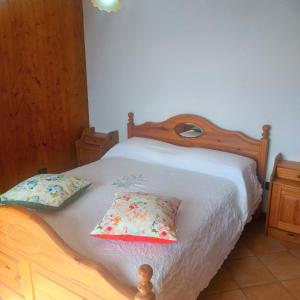 1 dormitorio con 1 cama de madera y 2 almohadas en Ulisse sul Sentiero, en Praiano