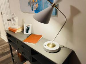 a desk with a lamp and a book on it at Large Renovated Cottage on East Lake Park in Birmingham