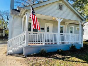 una casa con una bandera americana en el porche delantero en Large Renovated Cottage on East Lake Park en Birmingham