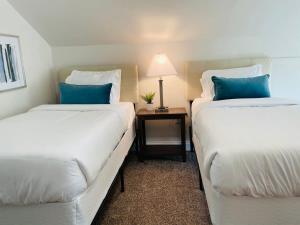 two beds in a hotel room with blue pillows at Large Renovated Cottage on East Lake Park in Birmingham