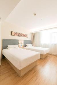 Llit o llits en una habitació de Hanting Hotel Baotou Donghe Railway Station