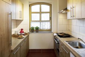 eine Küche mit einem Waschbecken und einem Fenster in der Unterkunft Holunderhaus in Rietz Neuendorf