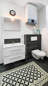 Un baño con inodoro blanco y suelo blanco y negro. en Apt. and garage : Train station, Univ, en Villeurbanne