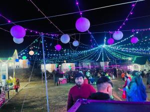 a group of people sitting under a tent with lights at SnowDrop eco resort in Chail