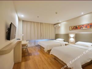 a hotel room with two beds and a flat screen tv at Hanting Hotel Rizhaoshan Haitian Road Wanpingkou Scenic Spot in Rizhao