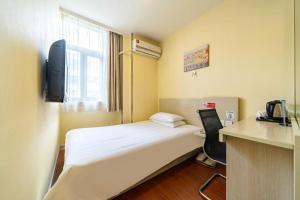 a room with a bed and a desk with a phone at Hanting Hotel Shanghai Qingpu Caoying Road Metro Station in Qingpu