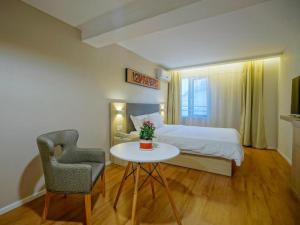 a bedroom with a bed and a table and a chair at Hanting Hotel Nanjing Hexi Jiqingmen Street in Nanjing
