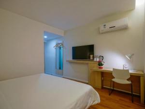 a bedroom with a bed and a desk and a tv at Hanting Hotel Nanjing Hexi Jiqingmen Street in Nanjing
