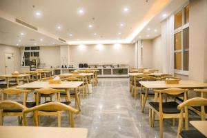 a restaurant with tables and chairs in a room at Starway Hotel Bozhou Yidu International Mall in Bozhou