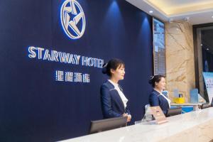 two women standing at a counter at a starway hotel at Starway Hotel Bozhou Yidu International Mall in Bozhou