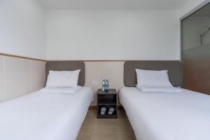 2 posti letto in una camera con lenzuola bianche e tavolo di Hi Inn Shanghai Global Harbor a Shanghai