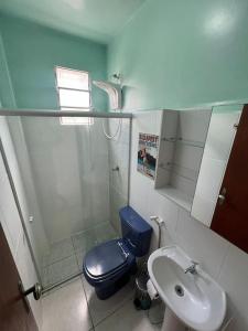 uma casa de banho com um WC azul e um lavatório. em 303-Apartamento Próximo ao Shopping Vila Velha em Vila Velha