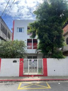 uma cerca branca e vermelha em frente a um edifício em 303-Apartamento Próximo ao Shopping Vila Velha em Vila Velha