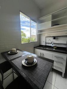 uma cozinha com uma mesa com duas chávenas em 303-Apartamento Próximo ao Shopping Vila Velha em Vila Velha