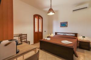 una camera con letto, scrivania e sedia di Dammuso Ignazio a Lampedusa