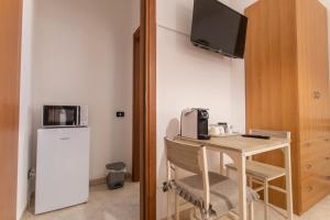 a room with a desk with a microwave and a refrigerator at Dammuso Ignazio in Lampedusa