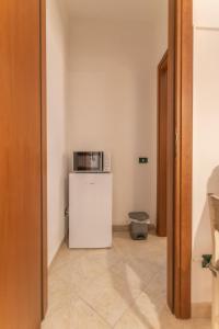 a small white refrigerator with a microwave on top of it at Dammuso Ignazio in Lampedusa