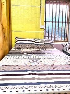 Ce lit se trouve dans un dortoir doté d'une fenêtre. dans l'établissement Tình Diễn homestay, à Quản Bạ