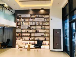 una biblioteca con sillas y libros en una pared en Hanting Hotel Shanghai Fengxian Nanqiao Bus Station, en Sanguantang