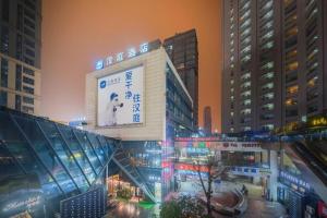un edificio con un cartel en una ciudad en Hanting Hotel Shanghai Fengxian Nanqiao Bus Station, en Sanguantang