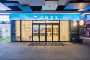un frente de tienda con un cartel azul en la puerta en Hanting Hotel Shanghai Fengxian Nanqiao Bus Station, en Sanguantang