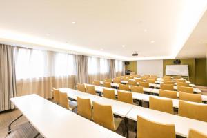 an empty lecture hall with tables and chairs at Ji Hotel Zhangjiakou Jiangong College in Zhangjiakou