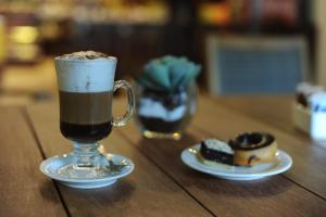a cup of coffee on a table with two desserts at Impressive Punta Cana - All Inclusive in Punta Cana