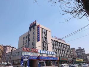 un edificio alto con muchas señales en él en Hanting Hotel Shenyang Nanta Shoe Market, en Shenyang