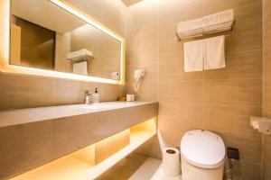 y baño con aseo, lavabo y espejo. en Ji Hotel Hangzhou Linping Xincheng, en Yuhang