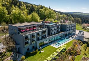an aerial view of a resort building with a swimming pool at Hüttenhof - Wellnesshotel & Luxus-Bergchalets - Adults only in Grainet
